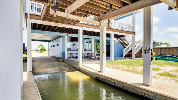 Un espace extérieur abrité comprenant une piscine, une terrasse en bois et une vue sur un immeuble d’habitation.