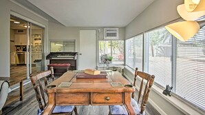 Un coin repas avec une table en bois, des chaises et un piano en arrière-plan.