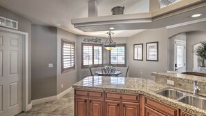 A kitchen with granite countertops, wooden cabinets, a central island, and a chandelier. - Lake Havasu City House w/ Fire Pit, Pool & Spa! (Lake Havasu City)