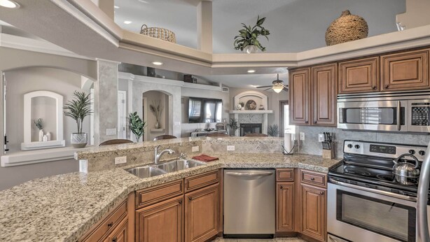 A kitchen with granite countertops, stainless steel appliances, wooden cabinets, and a built-in dishwasher. - Lake Havasu City House w/ Fire Pit, Pool & Spa! (Lake Havasu City)