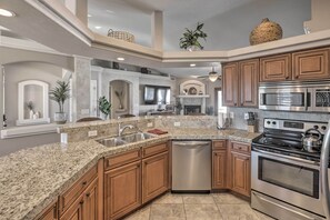 A kitchen with granite countertops, stainless steel appliances, wooden cabinets, and a built-in dishwasher. - Lake Havasu City House w/ Fire Pit, Pool & Spa! (Lake Havasu City)