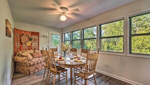 Un coin repas avec une table ronde, des chaises en bois et un ventilateur de plafond.