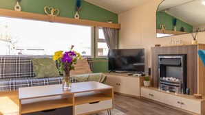 A living room with a sofa, TV, and fireplace. - Tattershall Lakes Private Hot Tub Lodge - Sleeps 6 (Lincoln)