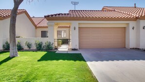 A residential house with a tiled roof, a garage, and a well-maintained lawn.