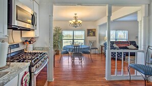 A spacious living area with a dining table, chairs, a sofa, and a staircase leading to another level. - Deck, Grill & Yard: Pet-friendly Van Alstyne Gem! (Van Alstyne)