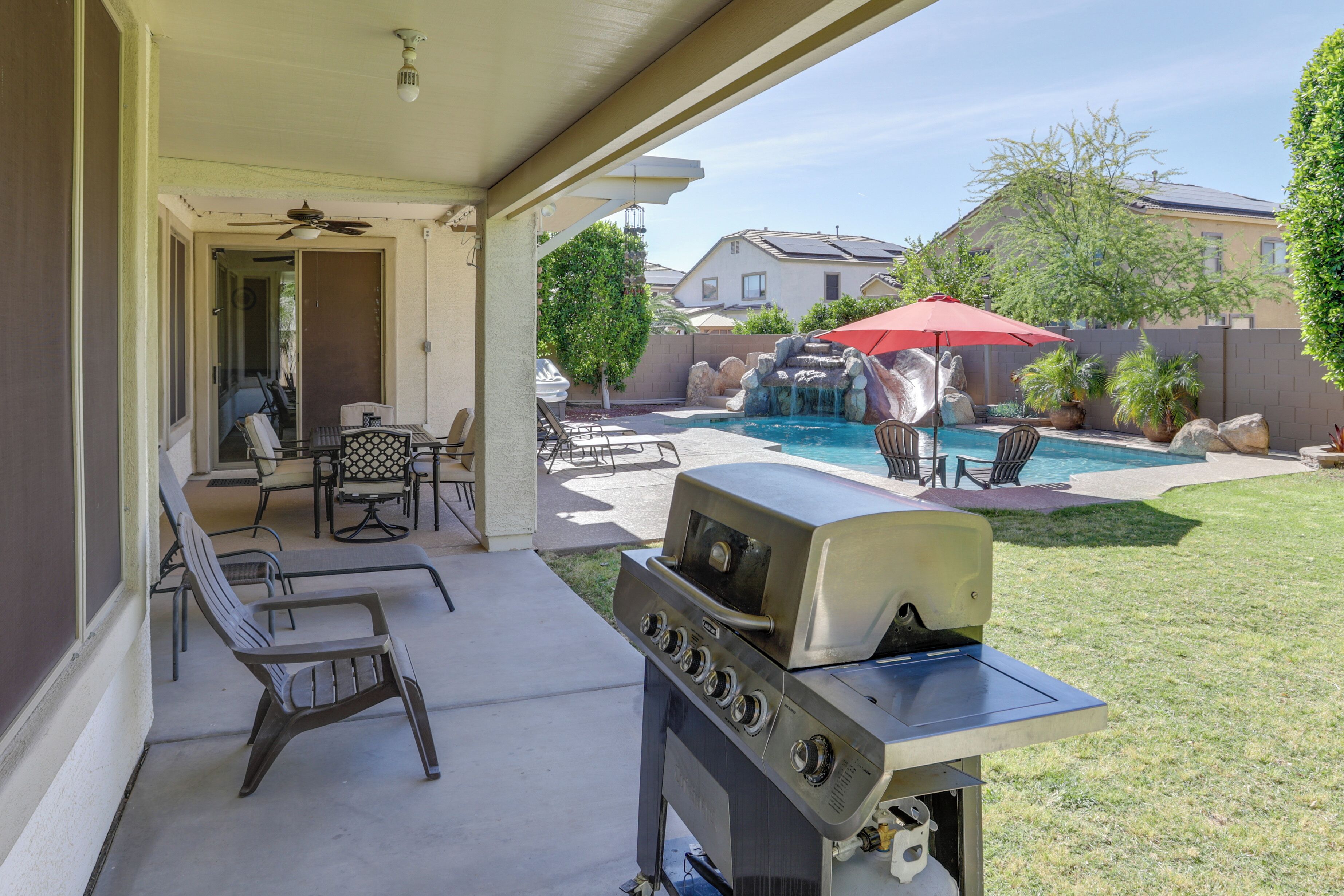 Ein Garten mit Grill, Sitzgelegenheiten im Freien, einem Swimmingpool und einer Terrasse.