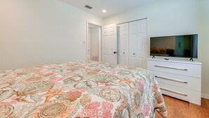 A bedroom with a bed, a TV, a wardrobe, and a ceiling fan. - Canalfront Port Charlotte Getaway w/ Boat Dock! (Port Charlotte)