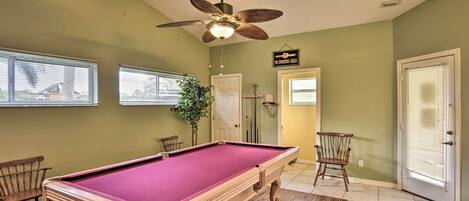 A pool table in a room with green walls, a ceiling fan, and a 'No Smoking Area' sign.
