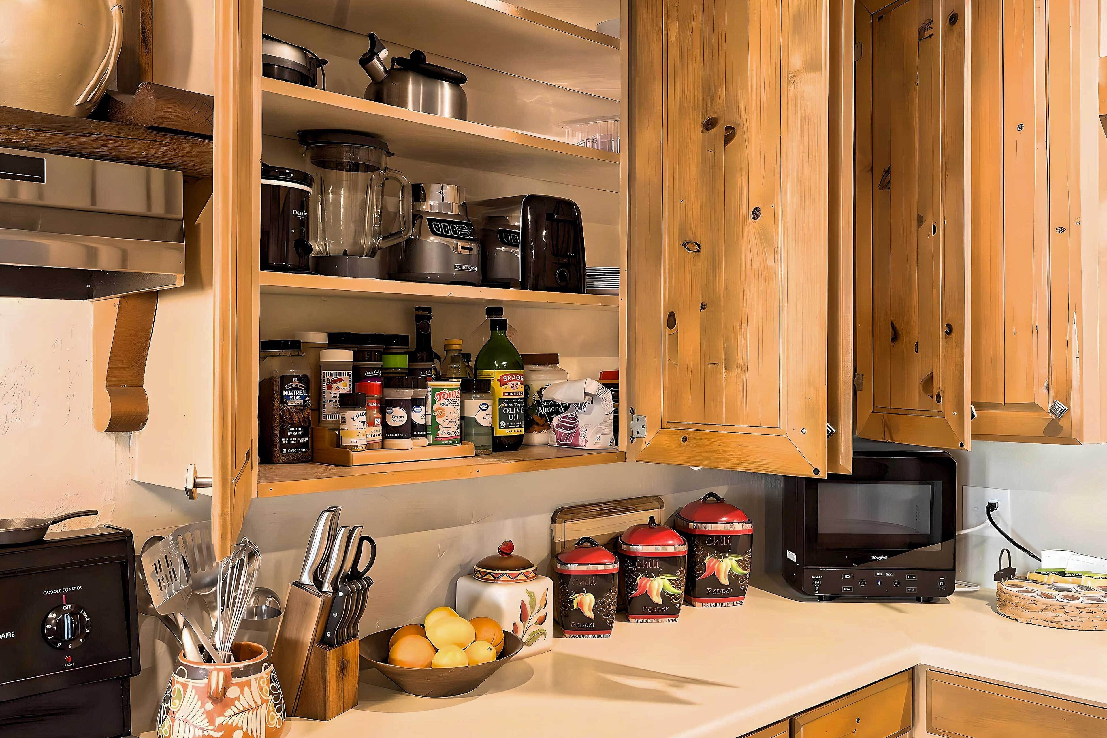 A kitchen with wooden cabinets, a stove, and various kitchen utensils and appliances.