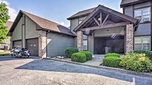 A two-story building with a garage and a covered driveway. - Branson West Villa w/ Golf Course View & Pool! (Branson West)