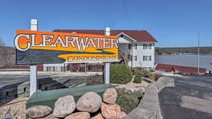 A sign for 'Clearwater Condominiums' with a view of a house and a body of water in the background. - Relax Poolside! 'serenity at the Lake' in Ozarks (Camdenton)