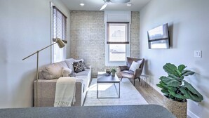 A modern living room with a sofa, coffee table, and a large plant. - Bright San Marcos Apartment w/ Ideal Location (San Marcos)