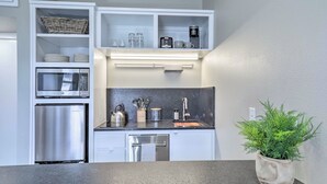 A compact kitchen with built-in appliances, a countertop with a potted plant, and storage cabinets. - Bright San Marcos Apartment w/ Ideal Location (San Marcos)