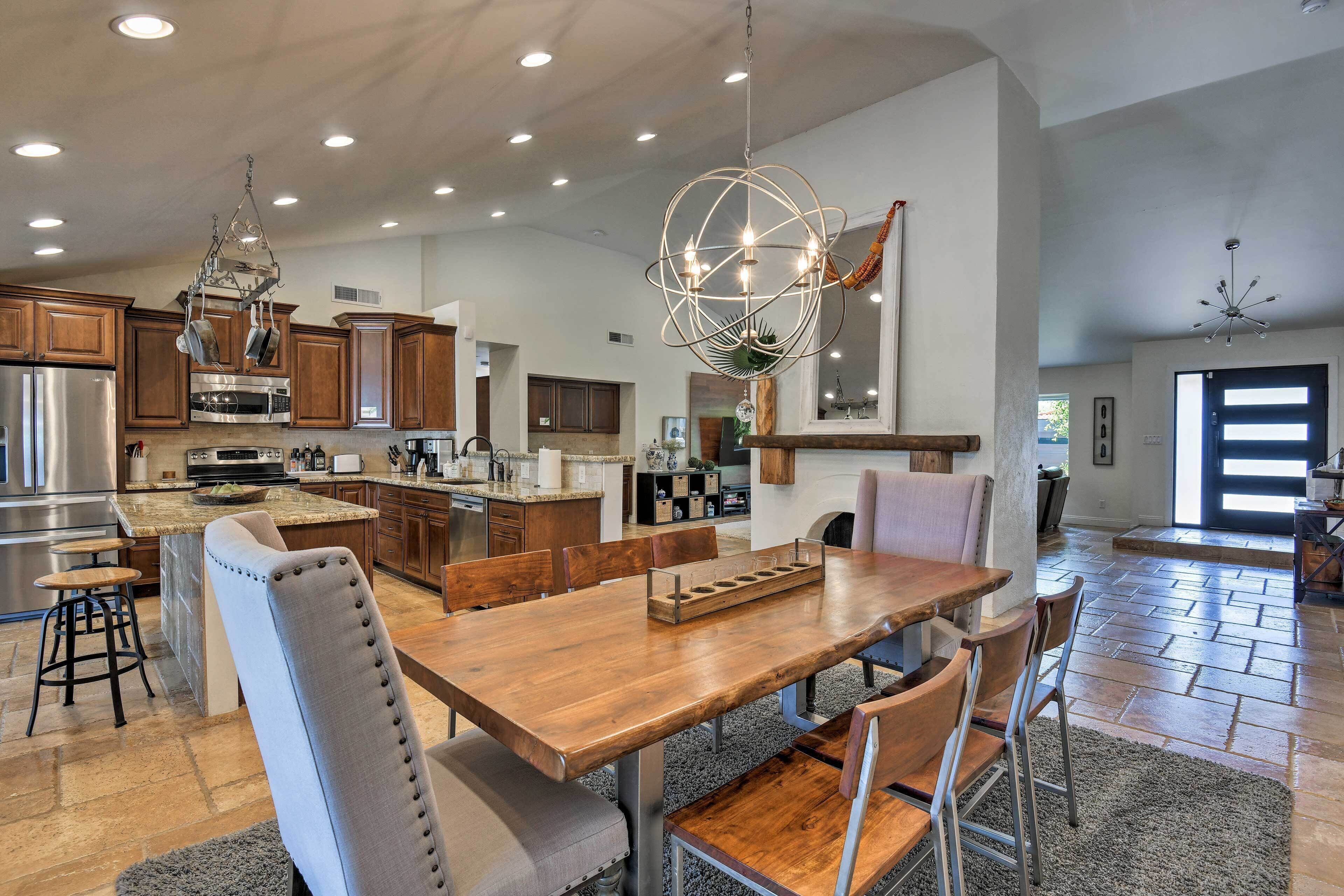 A spacious kitchen with modern appliances, a large dining table, and a unique spherical light fixture.