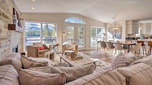 Un salon spacieux doté d’une cheminée, de grandes fenêtres et d’un coin salon confortable.