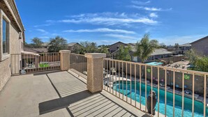 A residential area with a swimming pool, a wooden deck, and a stone pillar. - Private Pool & Hot Tub: San Tan Valley Home (San Tan Valley)