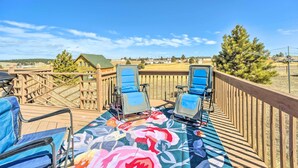 Une terrasse avec deux chaises longues bleues et une nappe à motifs floraux.