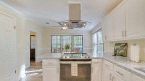 A kitchen with white cabinets, a built-in oven, a stainless steel range, and a window with blinds. - Stanardsville Cabin Rental ~ 24 Mi to Shenandoah! (Stanardsville)