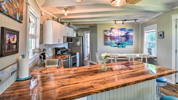 A kitchen with a wooden island, stainless steel appliances, and pendant lighting. - Furnished Deck & Dock: Renovated Sargent Cabin! (Bay City)