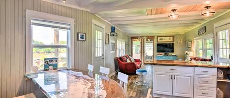 A spacious kitchen with a large island, wooden cabinets, and a view of the outdoors.