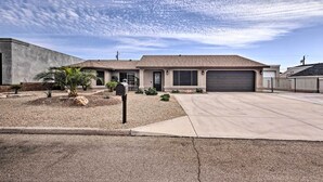 A residential house with a garage, a driveway, and a landscaped front yard with small plants and a mailbox.