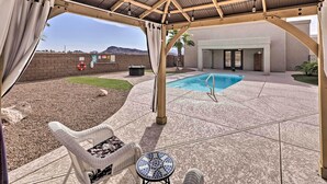 A covered patio with a pool, outdoor furniture, and a view of the mountains.
