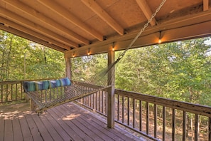 A hammock on a wooden deck with a view of a forest. - Mountain View Cabin w/ Wraparound Deck! (Mountain View)