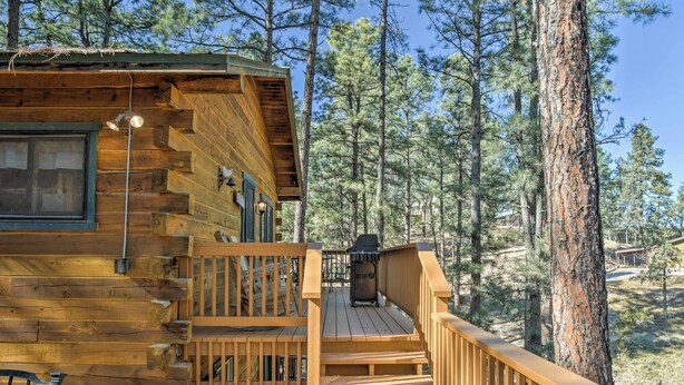 A wooden cabin with a deck, a window, and a grill. - Ruidoso Log Cabin Retreat - Peaceful & Convenient (Ruidoso)