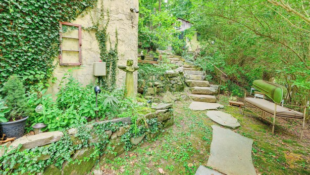 A narrow stone pathway flanked by lush greenery and a rustic stone wall. - Charming Getaway < 1 Mi to Downtown Lambertville! (Lambertville)