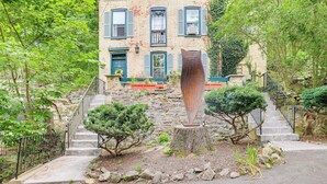 A multi-story building with a brick facade, blue shutters, and a central staircase leading to the entrance. - Charming Getaway < 1 Mi to Downtown Lambertville! (Lambertville)