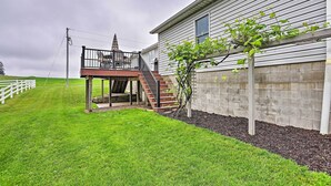 A two-story house with a balcony and a small staircase leading to the upper floor. - Millersburg Home w/ Covered Porch & Fire Pit! (Millersburg)