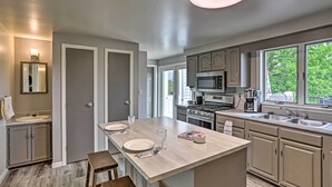 A modern kitchen with a central island, built-in appliances, and large windows. - Millersburg Home w/ Covered Porch & Fire Pit! (Millersburg)