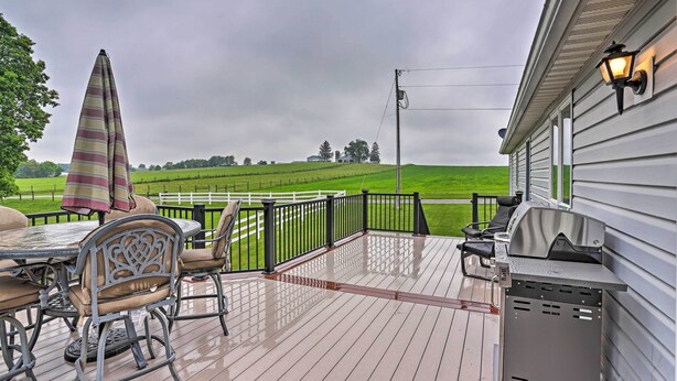 A covered outdoor deck with a grill, chairs, and a table. - Millersburg Home w/ Covered Porch & Fire Pit! (Millersburg)