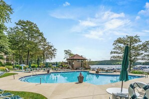 A swimming pool with lounge chairs and a small pavilion, surrounded by trees and overlooking a body of water. - Lake Harmony Condo < 1 Mi to Big Boulder Mountain! (Lake Harmony)