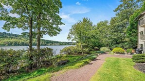 A pathway leading to a building with a view of a lake and trees. - Lake Harmony Condo < 1 Mi to Big Boulder Mountain! (Lake Harmony)
