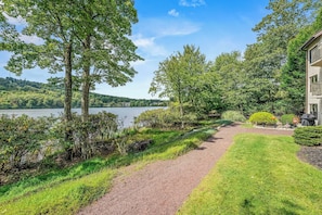 A pathway leading to a building with a view of a lake and trees. - Lake Harmony Condo < 1 Mi to Big Boulder Mountain! (Lake Harmony)