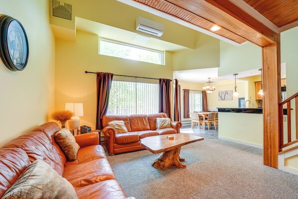 A living room with a sofa, coffee table, and a dining area with chairs and a table. - Lake Harmony Condo < 1 Mi to Big Boulder Mountain! (Lake Harmony)