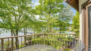 A balcony with a metal railing, a round metal table, and two chairs. - Lake Harmony Condo < 1 Mi to Big Boulder Mountain! (Lake Harmony)