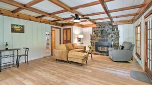 A cozy living room with a stone fireplace, wooden beams, and a sectional sofa. - Wine Country Escape w/ Hot Tub in River Pines! (River Pines)