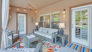 A cozy outdoor seating area with a sofa, two side tables, and a patterned rug. - Fenced Hot Tub & Bbq: Modern Scottsdale Retreat (Scottsdale)