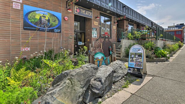 A theater with a brick facade, a large outdoor advertisement, and a sidewalk with a signboard. - Idyllic Dtwn Anchorage Condo w/ Fireplace! (Anchorage)