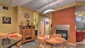A dining area with a round table, wooden chairs, a black countertop, and a fireplace. - Idyllic Dtwn Anchorage Condo w/ Fireplace! (Anchorage)