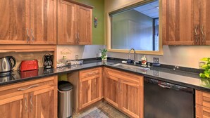 A kitchen with wooden cabinets, a black countertop, and a Bosch dishwasher. - Idyllic Dtwn Anchorage Condo w/ Fireplace! (Anchorage)