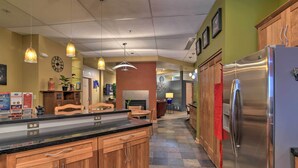 A kitchen with wooden cabinets, a stainless steel refrigerator, and pendant lighting. - Idyllic Dtwn Anchorage Condo w/ Fireplace! (Anchorage)