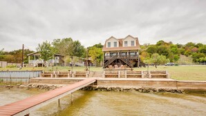 A house with a dock extending into a pond. - Lake Granbury Fishing Escape w/ Dock & Kayaks! (Granbury)