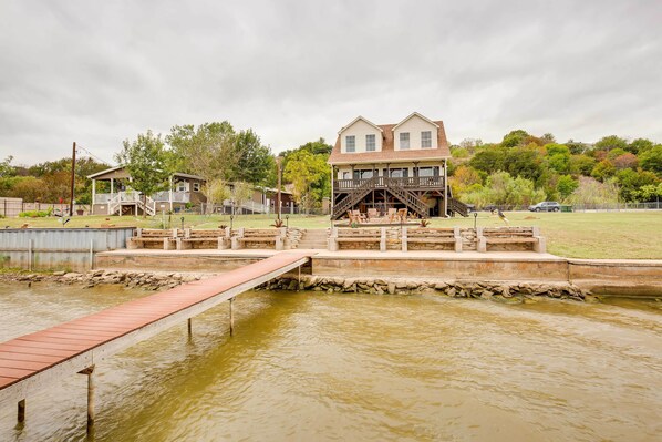 A house with a dock extending into a pond.