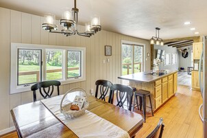 Una cocina amplia con armarios de madera, una isla central y ventanas grandes con vistas al exterior.