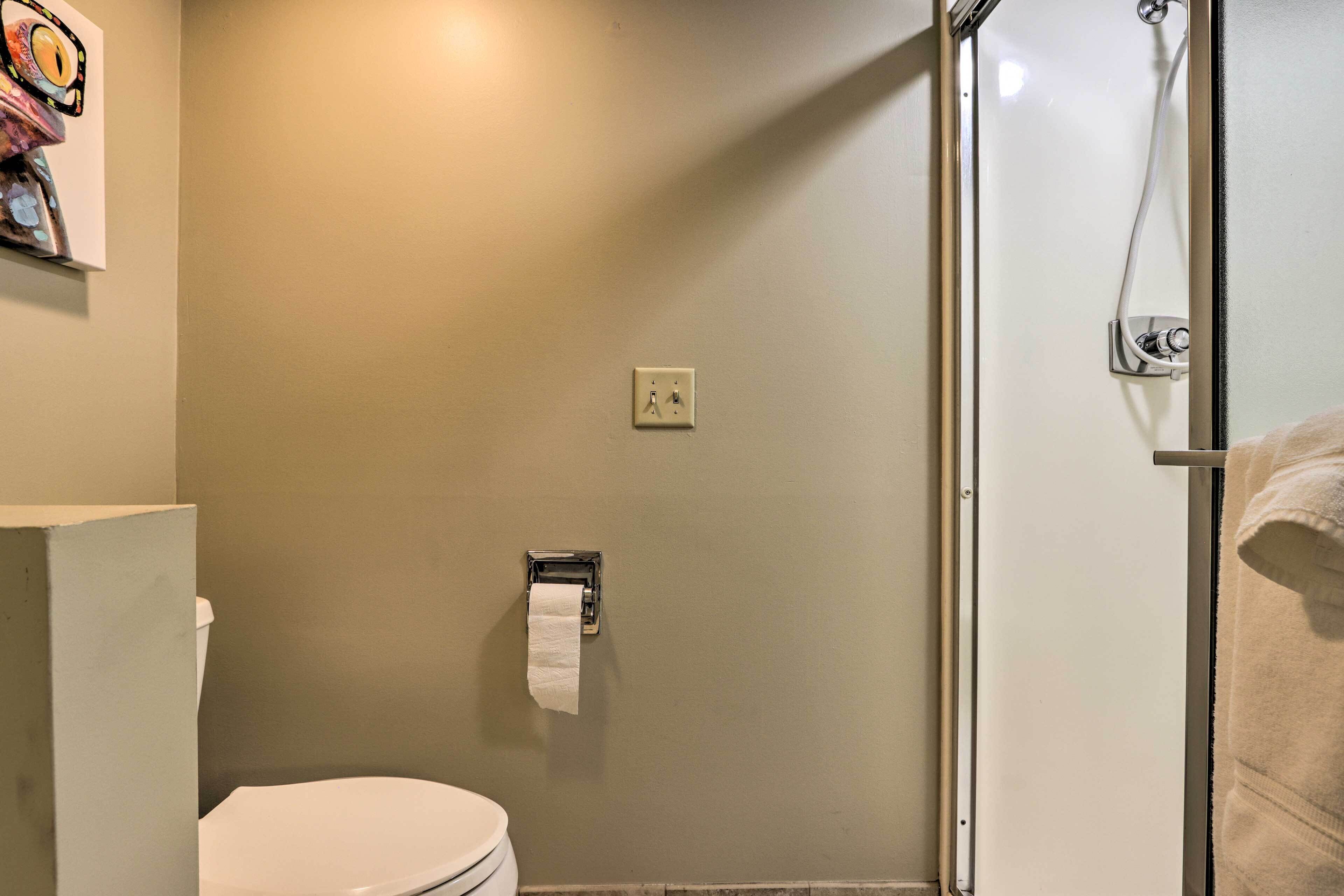 Une salle de bain comprenant des toilettes, un porte-serviettes et un espace douche.