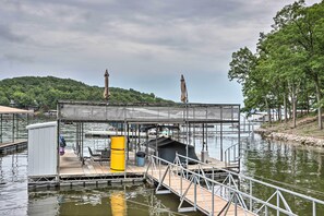 A dock with a covered seating area, a yellow barrel, and a small shelter. - Lakefront Haven: Family-friendly Sunrise Beach Gem (Sunrise Beach)