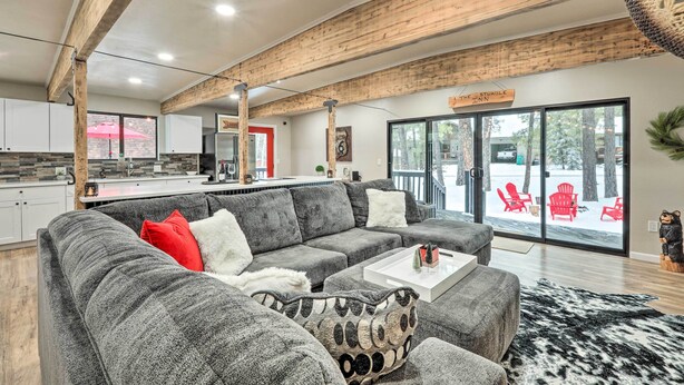 Een moderne woonkamer met een grijze modulaire bank, een witte salontafel en een zwart-wit kleed.